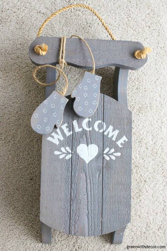 Outdated blue wood sled with'welcome' written on it