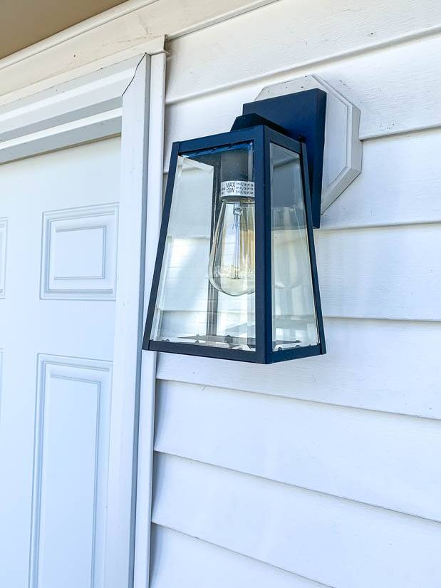 Dark outdoor light on white siding