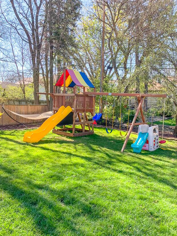 Swing set in backyard with trees