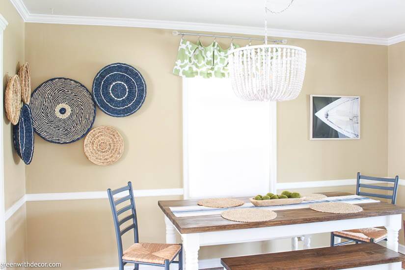 Boho coastal dining room with a seagrass basket gallery wall and beaded chandelier