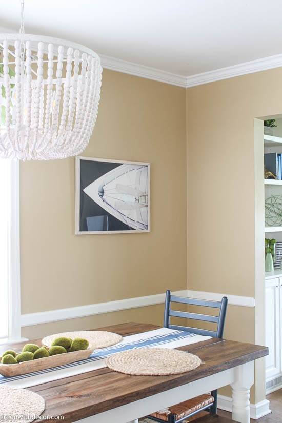 Camelback dining room with a white beaded chandelier and boat artwork