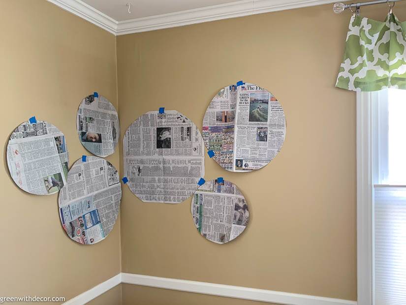 Tan dining room with newspaper pieces laid out for a seagrass basket gallery wall
