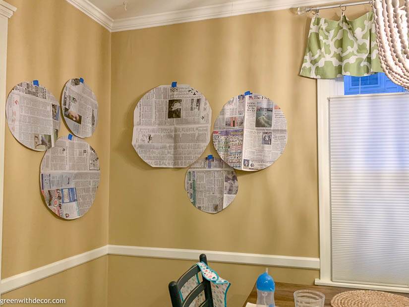 Tan dining room with newspaper laid out for a seagrass basket gallery wall