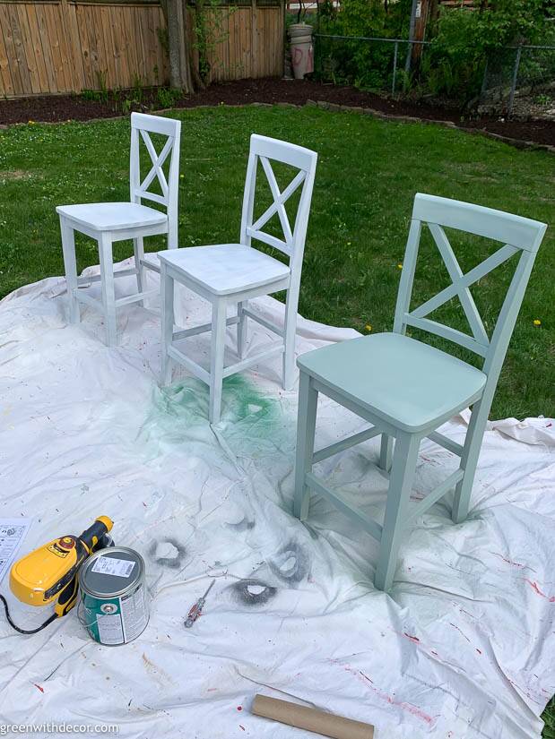 Three barstools being painted outside