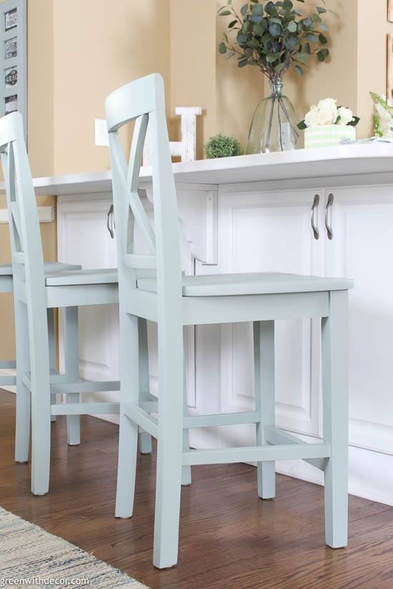 Blue painted barstools at a white breakfast bar