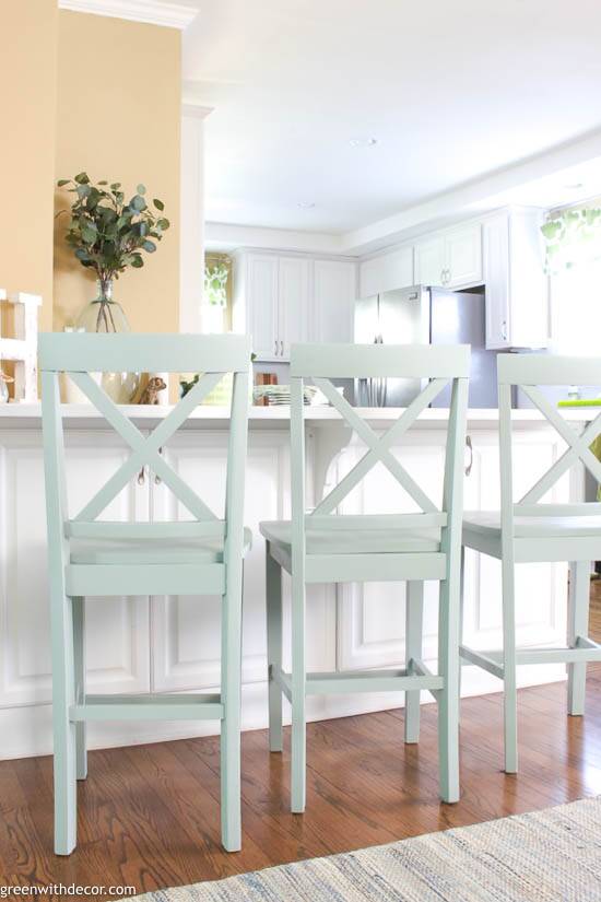 A white kitchen with blue painted barstools