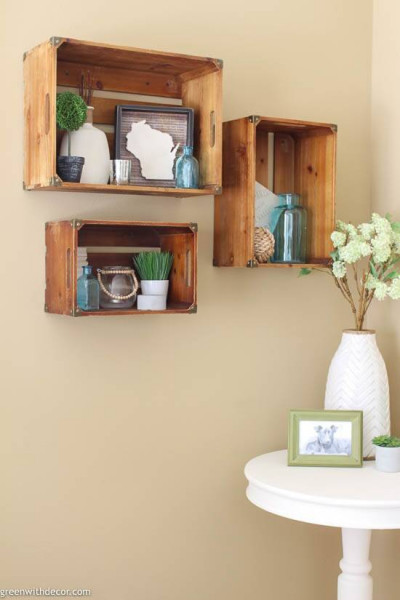 3 wood crate shelves on a tan wall near a white round table