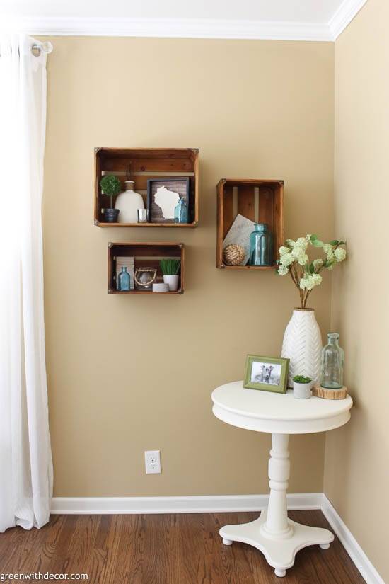 Wood crate shelves on a tan wall with white curtains