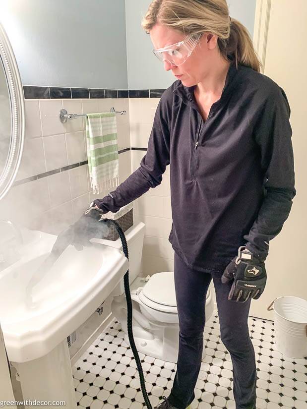 A girl using a stem cleaner to clean a bathroom sink