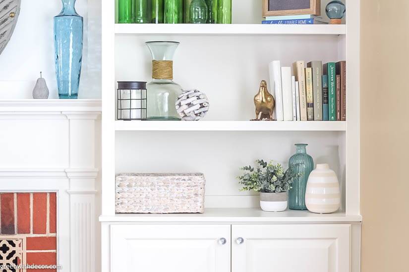 A close-up of bookshelf decorations next to a fireplace