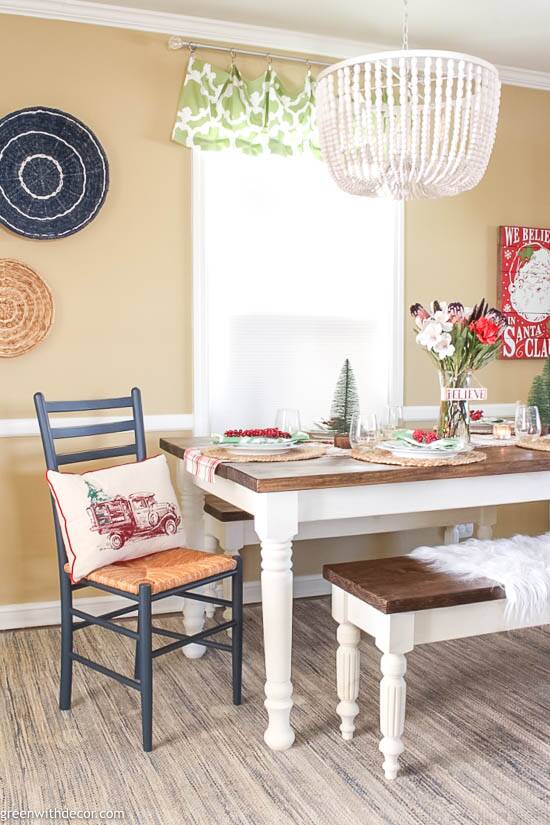 A coastal dining room with a Christmas centerpiece and throw pillow