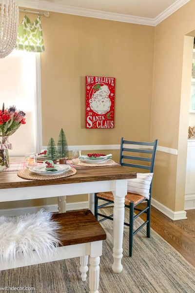 A coastal dining room with a Christmas centerpiece and Santa artwork