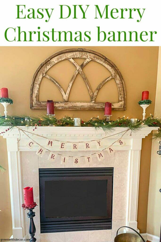 A DIY Christmas banner and green garland on a white mantel