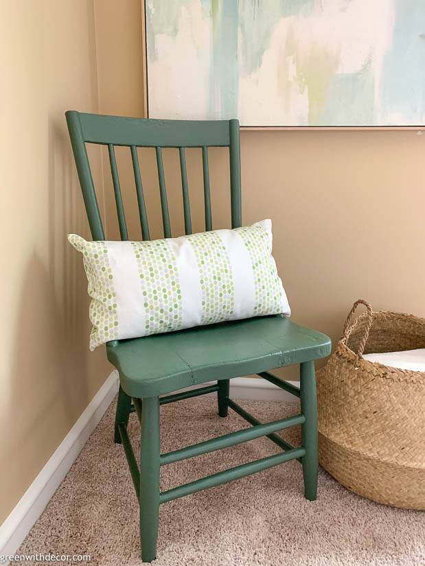 A painted chair with a white and green pillow