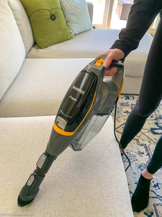 Vacuuming a gray couch