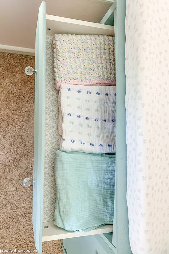 Swaddle blankets on drawer liners in blue dresser
