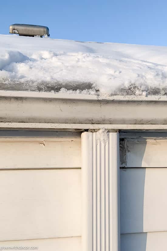 Major ice dam backed up in a gutter on a snowy roof