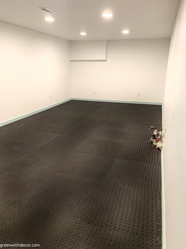 Basement with black flooring, blue trim + whtie walls