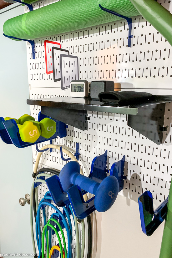 Storing gym equipment on white pegboards